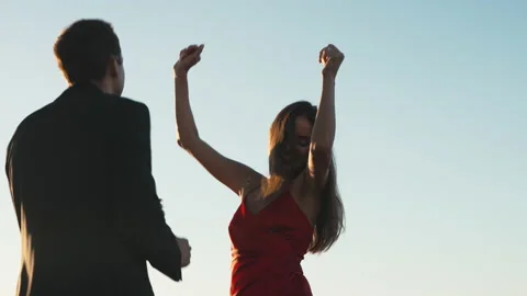 Couple in love on a romantic date dancing on the roof of a building at sunset Stock Footage 201426606