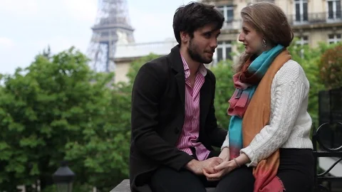 Couple in love sitting on Eiffel tower background in Paris Stock Footage 98093934