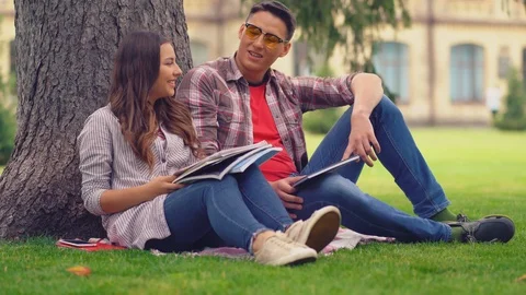 Couple in love talking leaned on tree and prepare for exsams Stock Footage 126722026