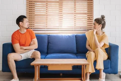Couple lover unhappy looking at empty product on the sofa. Stock Photos