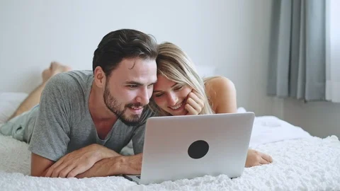 Couple lover using laptop for online shopping, internet, on white bed Stock Footage 111878622