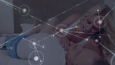 Couple lying on bed initial node appearing causing technology network nodes Stock Footage 314717160