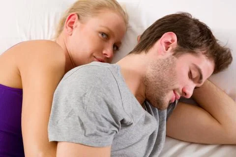 Couple lying in bed Stock Photos