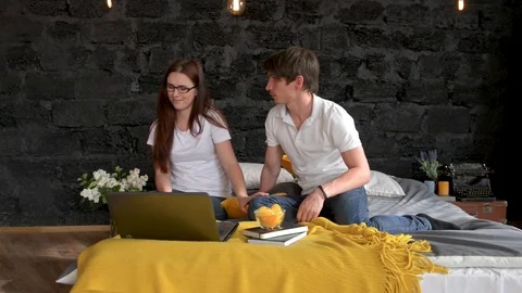 Couple Lying In Bed Use Laptop Computer Happy Smile Chatting Online and eating Stock Footage 75847149
