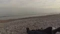 Couple lying on blanket on beach and talking, waves rolling over seashore, date 4k or 4k+ Resolution