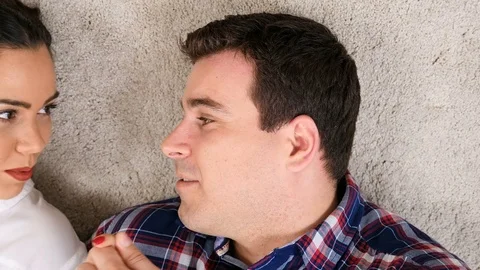 Couple lying down on the floor smiling and laughing Stock Footage 84889576