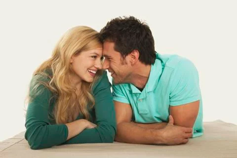 Couple lying on front and rubbing noses, smiling, close up Stock Photos