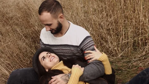 Couple is lying in the grass and cuddling. talking and smiling. Nice date Stock Footage 117358046
