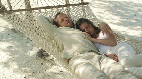 Couple lying on hammock waking up from nap, luxury resort HD Stock Footage 34512481