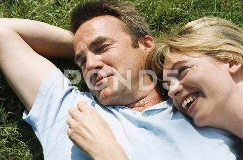Couple lying outdoors smiling Stock-Fotos