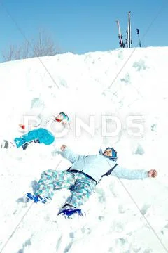 Couple lying in snow and looking at sky Stock Photos