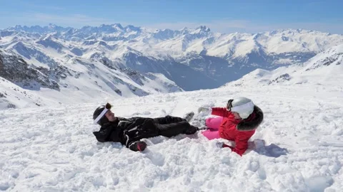 Couple lying in snow, playing with snowballs, mountain landscape Stock-Footage 317093756