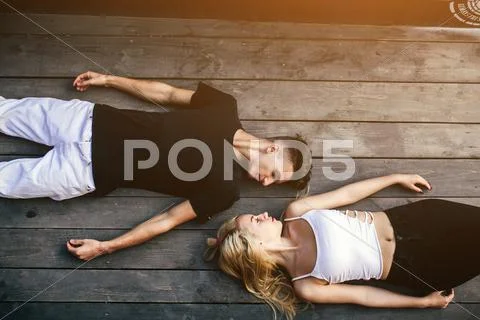 Couple lying together on the hardwood floor Stock Photos