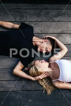 Couple lying together on the hardwood floor Stock Photos