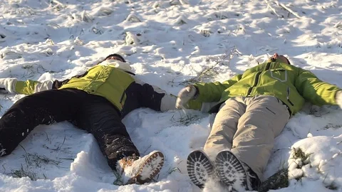 Couple makes snow angels Stock Footage 100267084