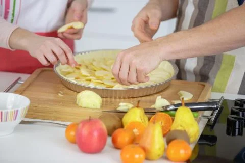 Couple making apple cake at kitchen Stock Photos