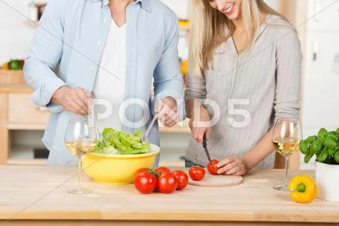 Couple making salad together at kitchen counter Stock Photos