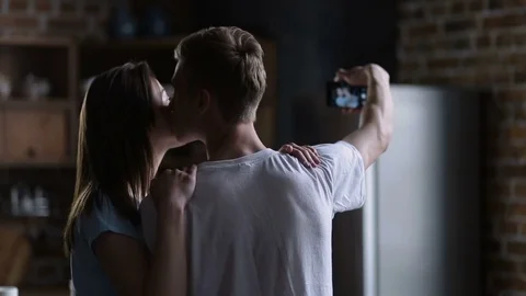 Couple making self-portrait on smart phone at home Stock Footage 74923412