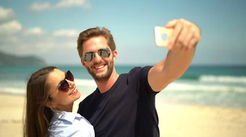 Couple making selfies on the beach Stock Footage 62674029