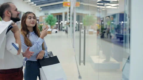 Couple in the mall in front of the showcase Stock Footage 96743899