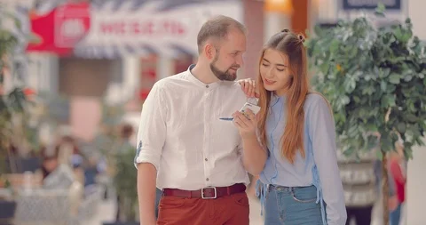 Couple in the mall selects something in the phone application Video stock 95966357