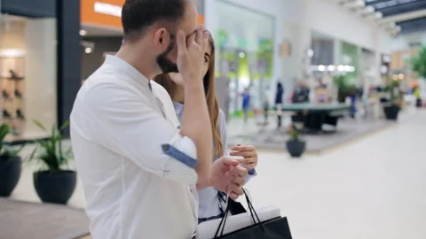 Couple in the mall is standing in front of the storefront and picks the goods Stock Footage 98307017