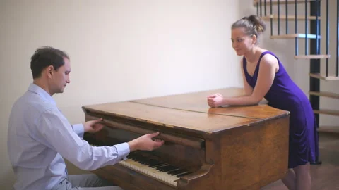 Couple man playing vintage piano, woman listening clapping in studio Stock Footage