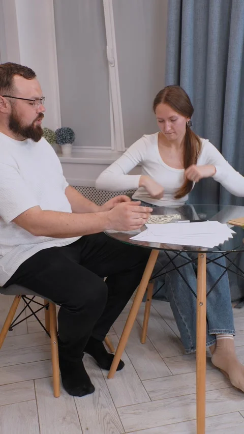 Couple managing home finances, counting dollars and discussing budget Stock-Footage 317444780