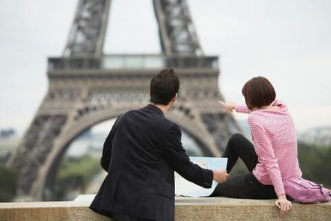 Couple With Map Looking At Eiffel Tower Foto stock