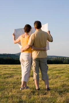Couple with map in a meadow Stock Photos