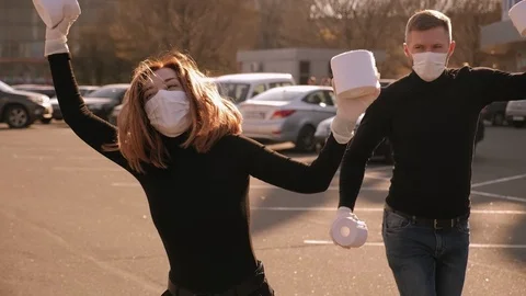 Couple in medical masks having fun in the parking with toilet paper. COVID-19. Stock Footage 128317200