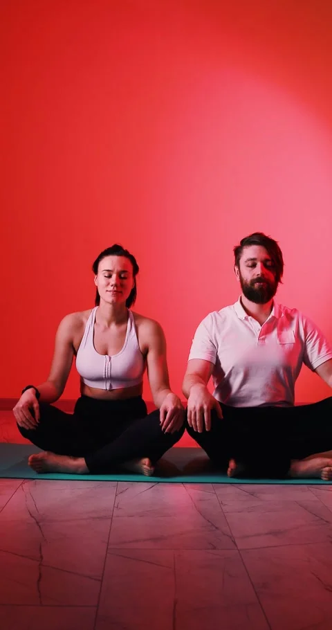 Couple Meditating in Lotus Pose in Harmony, Red Vertical Video Stock Footage 326539452