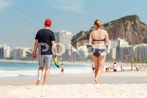 Couple of middle-aged people walking on Copacabana beach (Rio de Janeiro, Bra Stock Photos