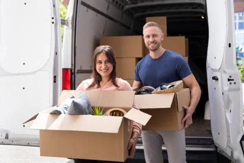 Couple Moving Boxes From Van Or Truck Stock Photos