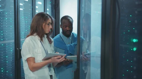 Couple of multi-race man and woman server technicians doing network data Stock Footage 119783131