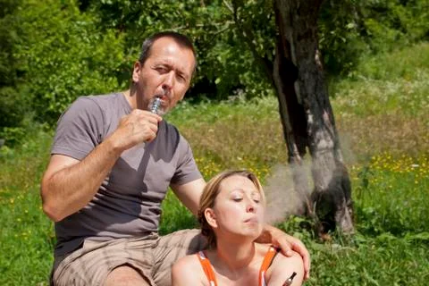 Couple in nature with e-cigarettes 库存照片