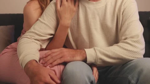 Couple nestling close on sofa, sharing tender moment with intertwined limbs.. Video stock 305695157
