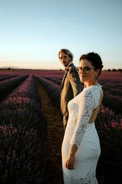 Couple of newlyweds walking in lavender field Stock Photos
