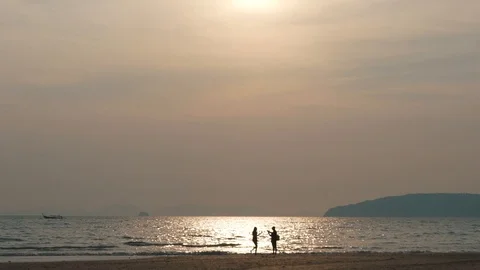 Couple by the ocean at sunset Stock Footage 106346961