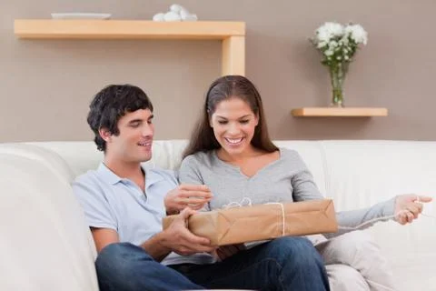 Couple opening parcel on the sofa Photos