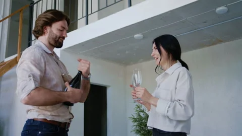 Couple Opens Champagne Bottle in Spacious New Property 库存影片 311812366