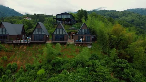 Couple operating drone from mountain cabin balcony retreat Stock Footage 344654225