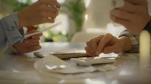 Couple organizing and calculating finances with receipts on a bright table a Stock Footage 323733713