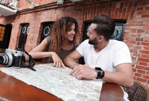 Couple in an outdoor cafe using map and planning itinerary Fotos Stock