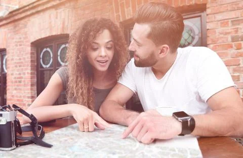 Couple in an outdoor cafe using map and planning itinerary Fotos Stock