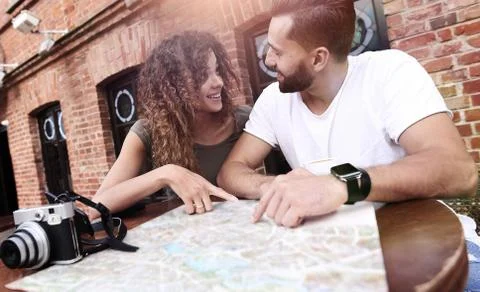 Couple in an outdoor cafe using map and planning itinerary Fotos Stock