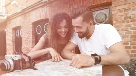 Couple in an outdoor cafe using map and planning itinerary Fotos Stock