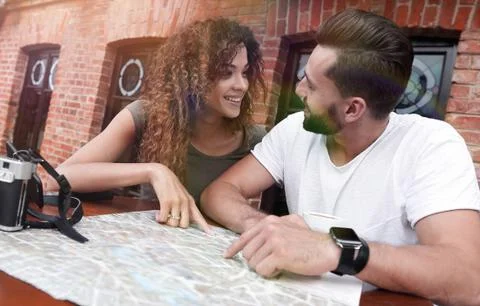 Couple in an outdoor cafe using map and planning itinerary Fotos Stock