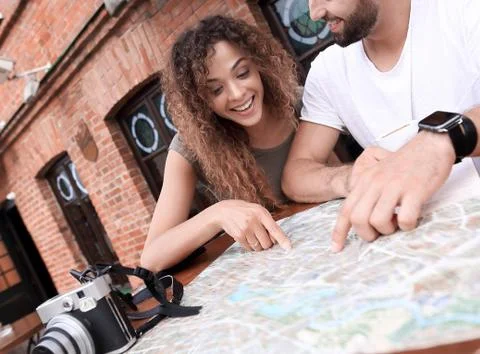 Couple in an outdoor cafe using map and planning itinerary Fotos Stock