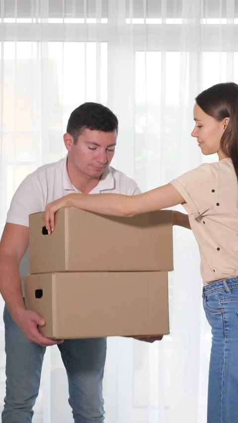 Couple packing and stacking cardboard boxes together Stock Footage 341189669
